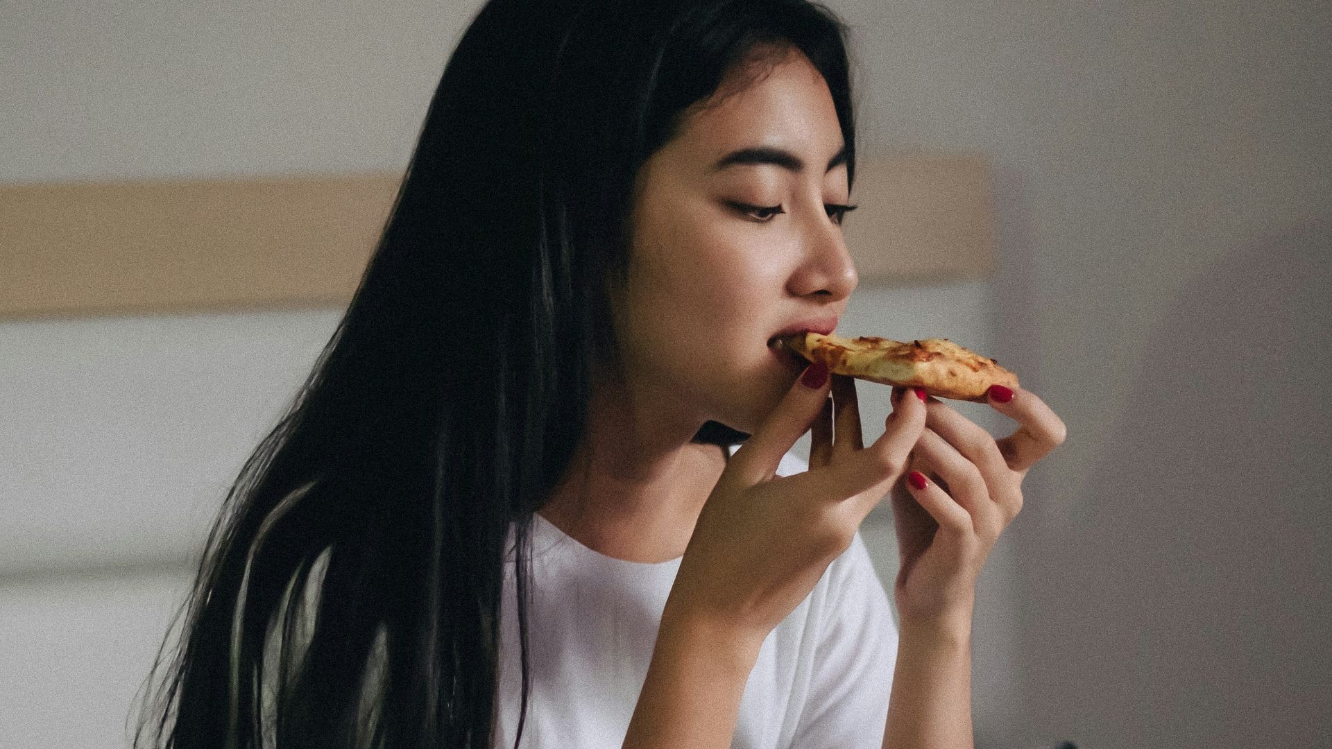 sitting woman in bed eating pastry