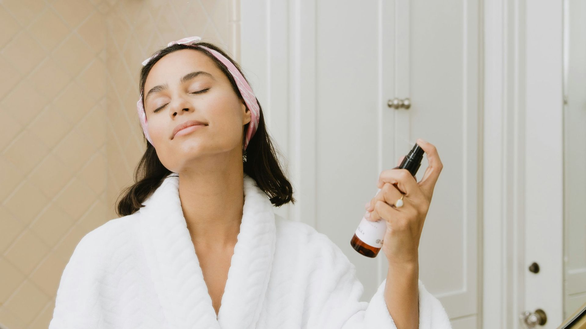 woman in white bathrobe holding smartphone