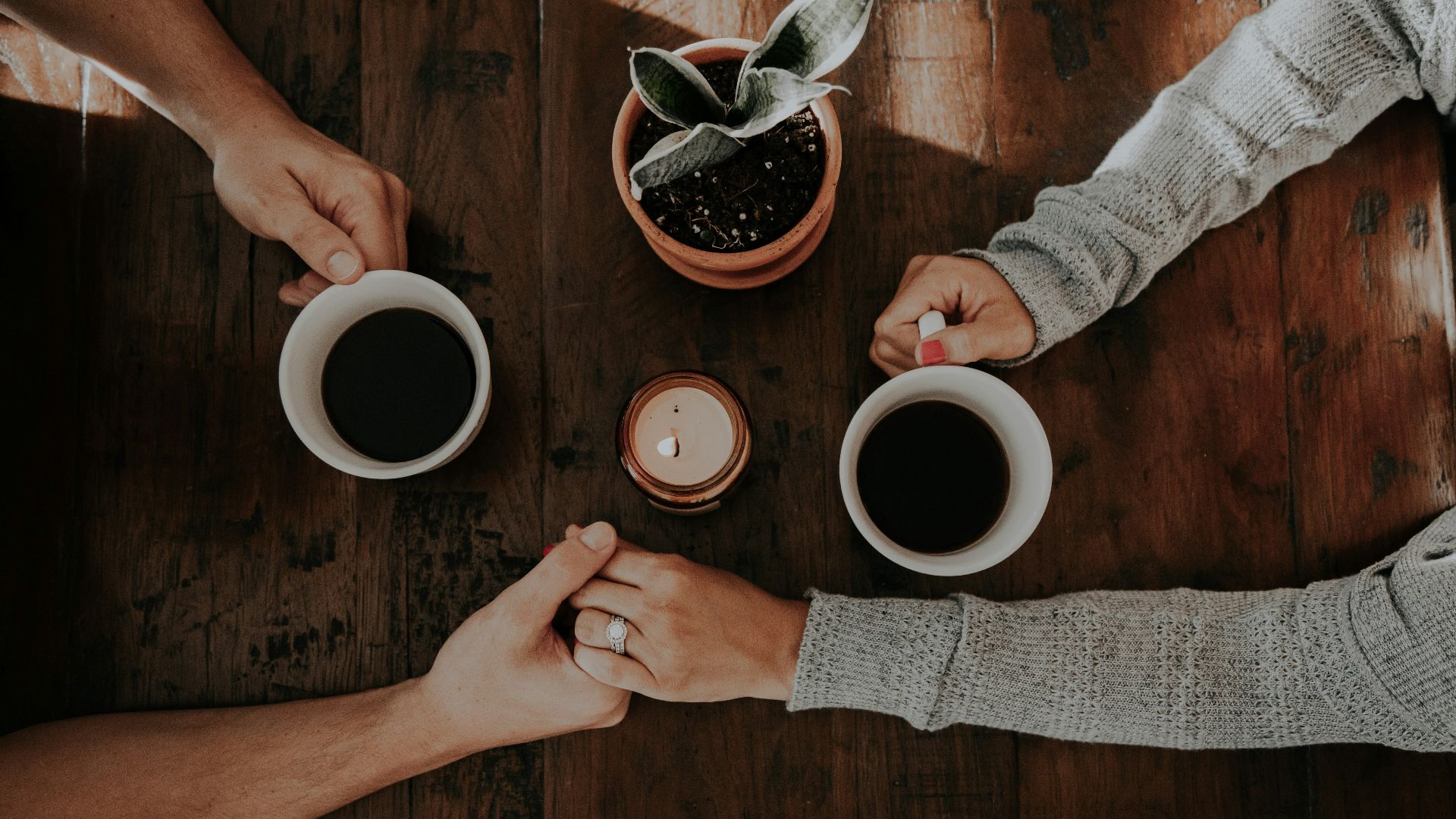 person holding white ceramic mugs