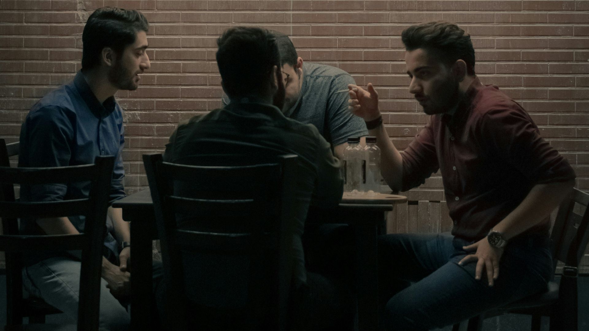 four men sitting beside table