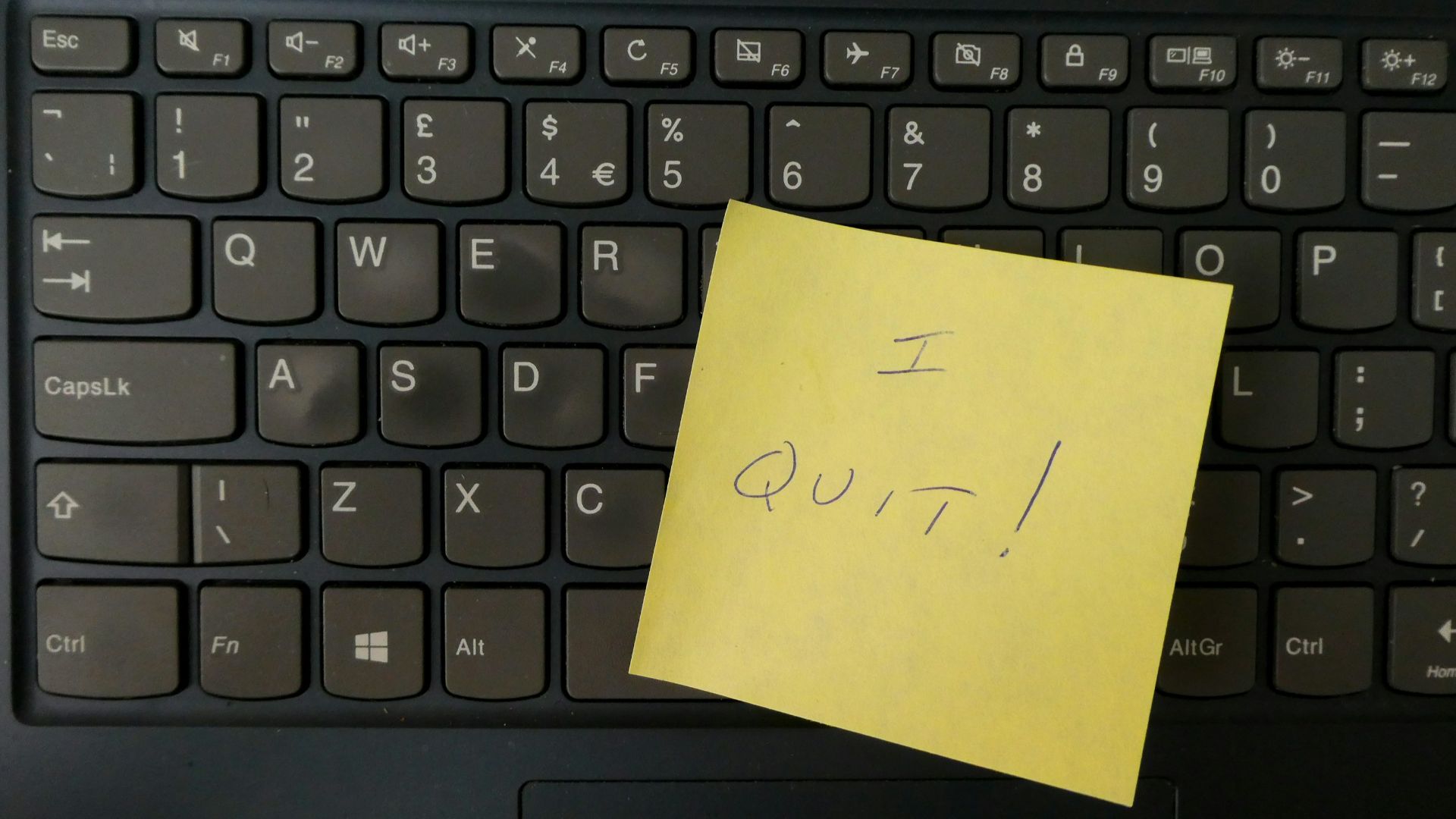 a yellow notepad on a keyboard