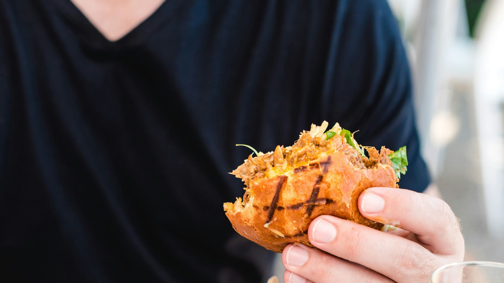 person holding bread in fruit of fried fries on white table