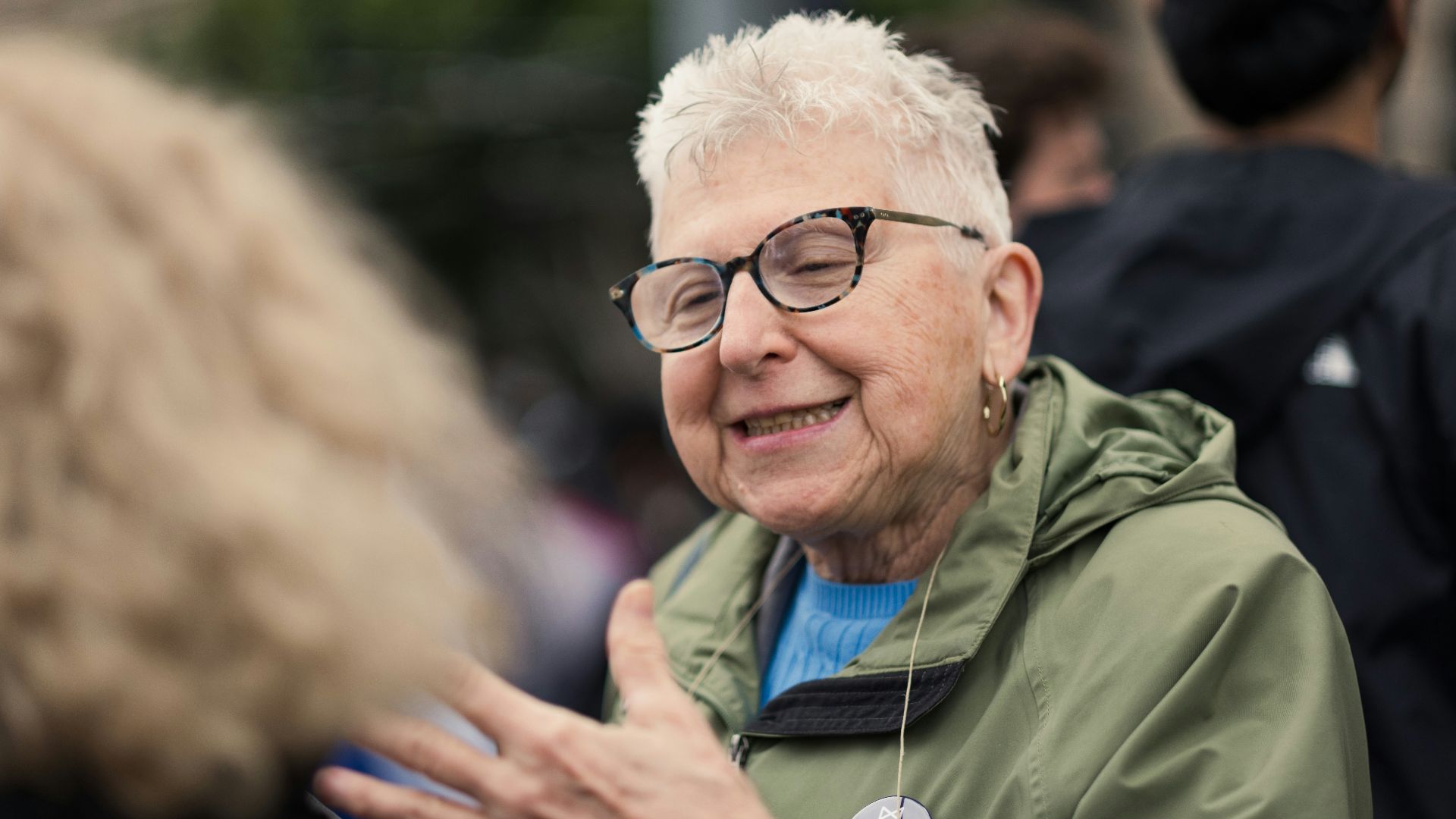 a woman with glasses talking to another woman