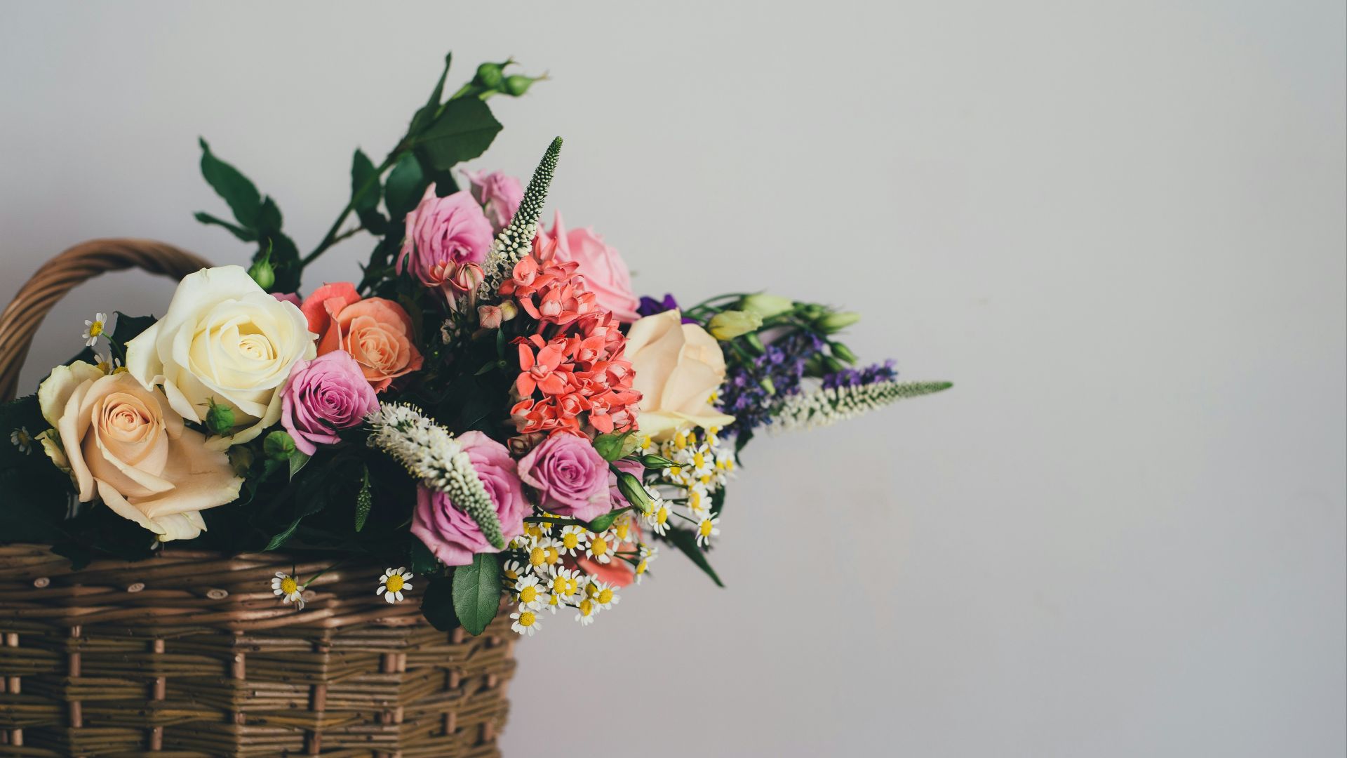 assorted-color flowers on brown wicker basket