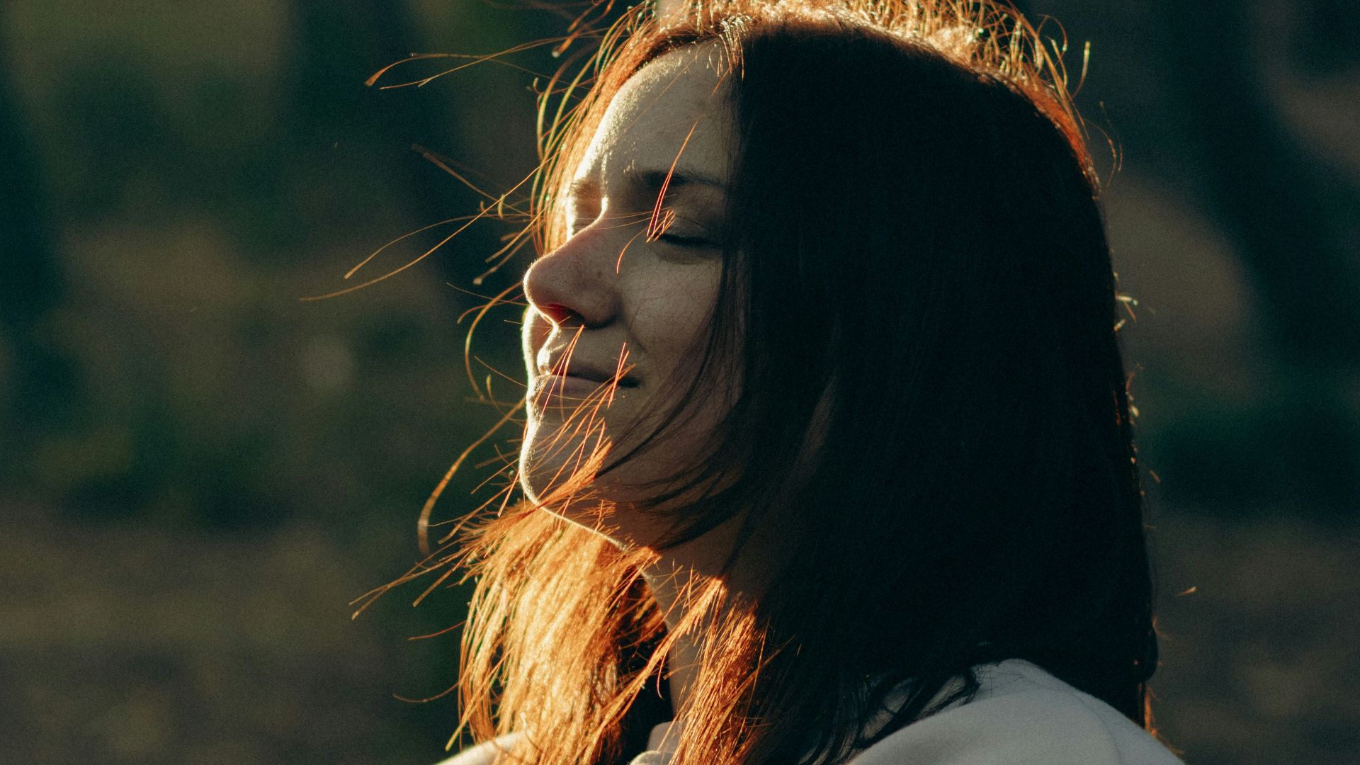 A woman standing in the woods with her face painted