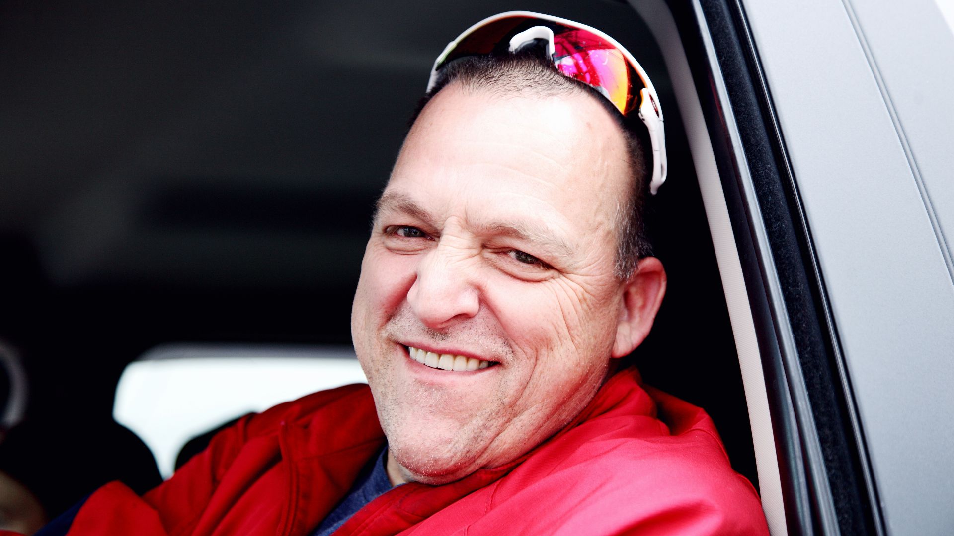 man in red dress shirt wearing black sunglasses