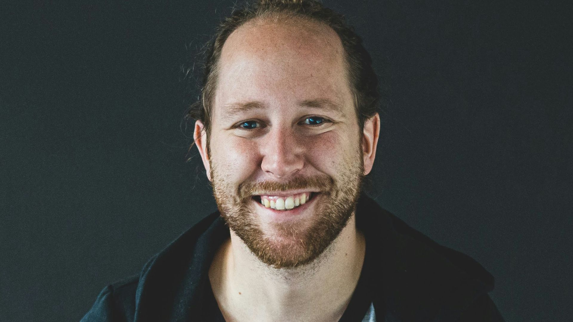 man in black jacket smiling