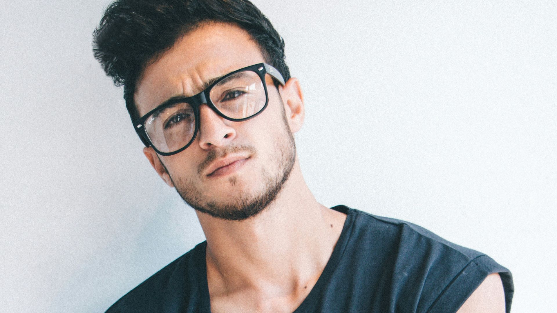 man wearing eyeglasses and sleeveless top