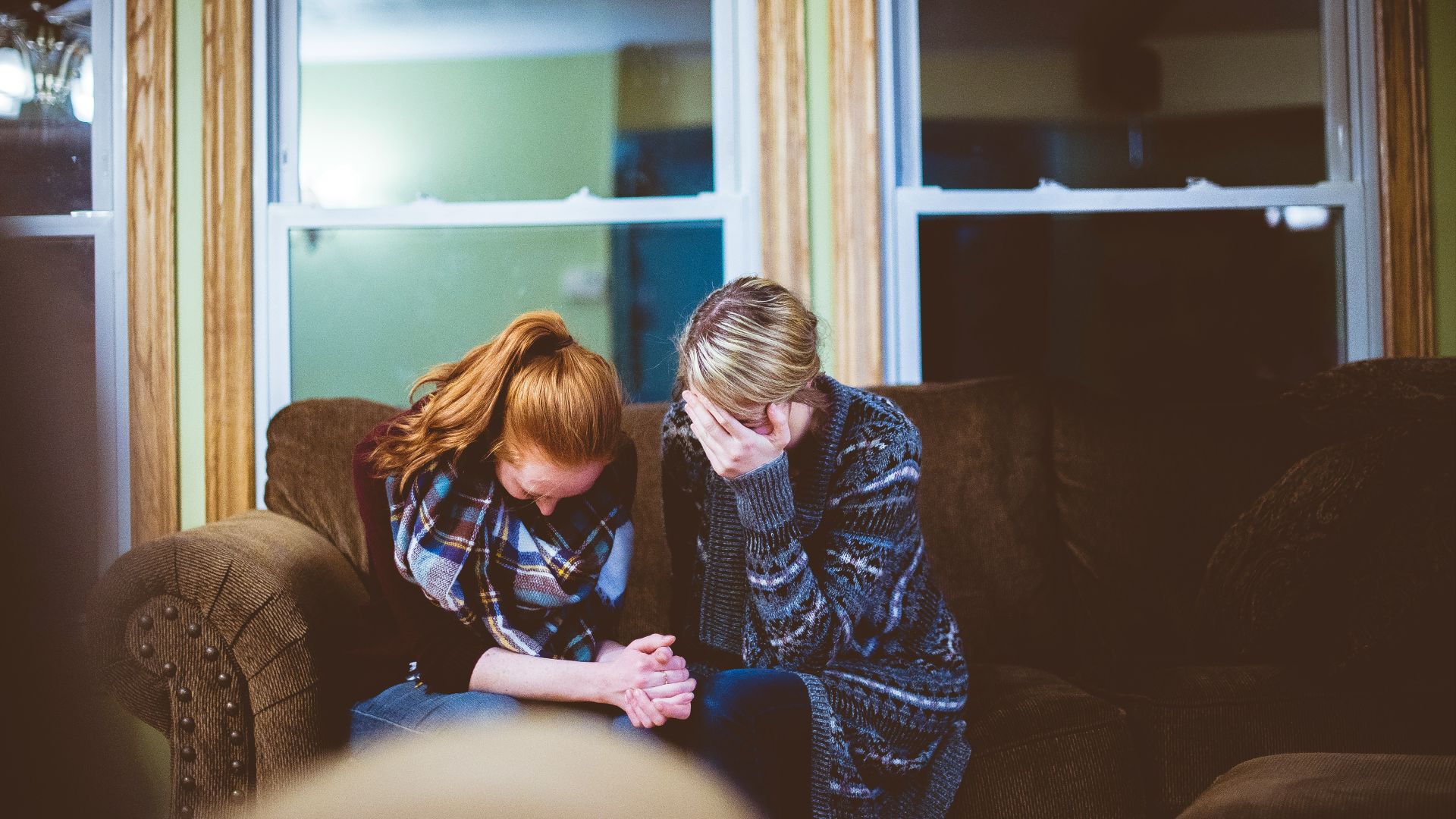 man and woman sitting on sofa in a room