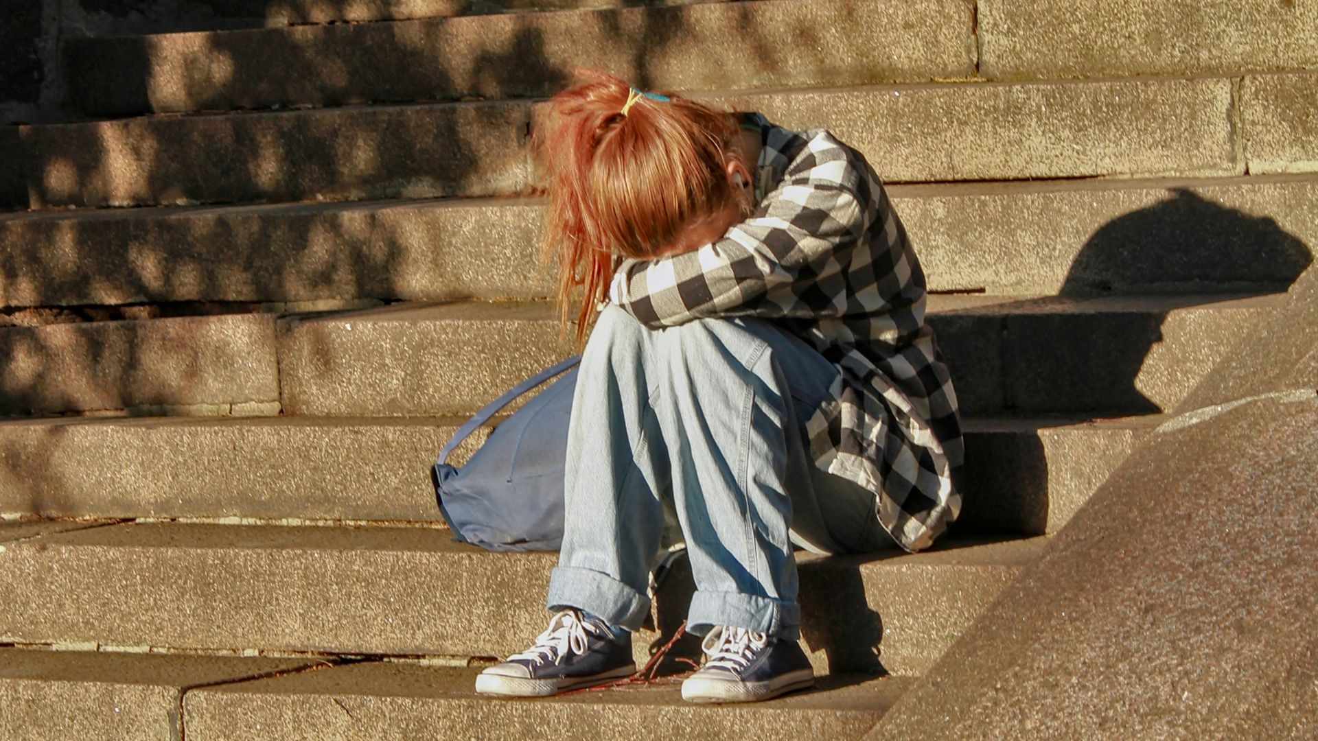 woman in black and white dress sitting on concrete stairs