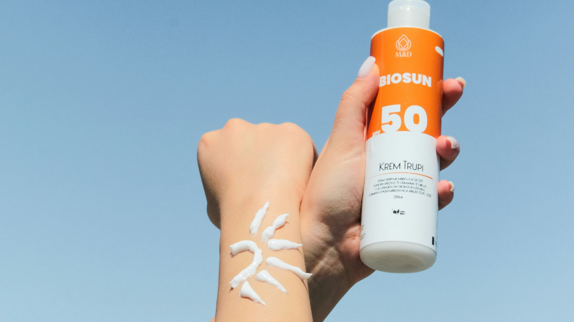 a person holding a bottle of sunscreen in their hand