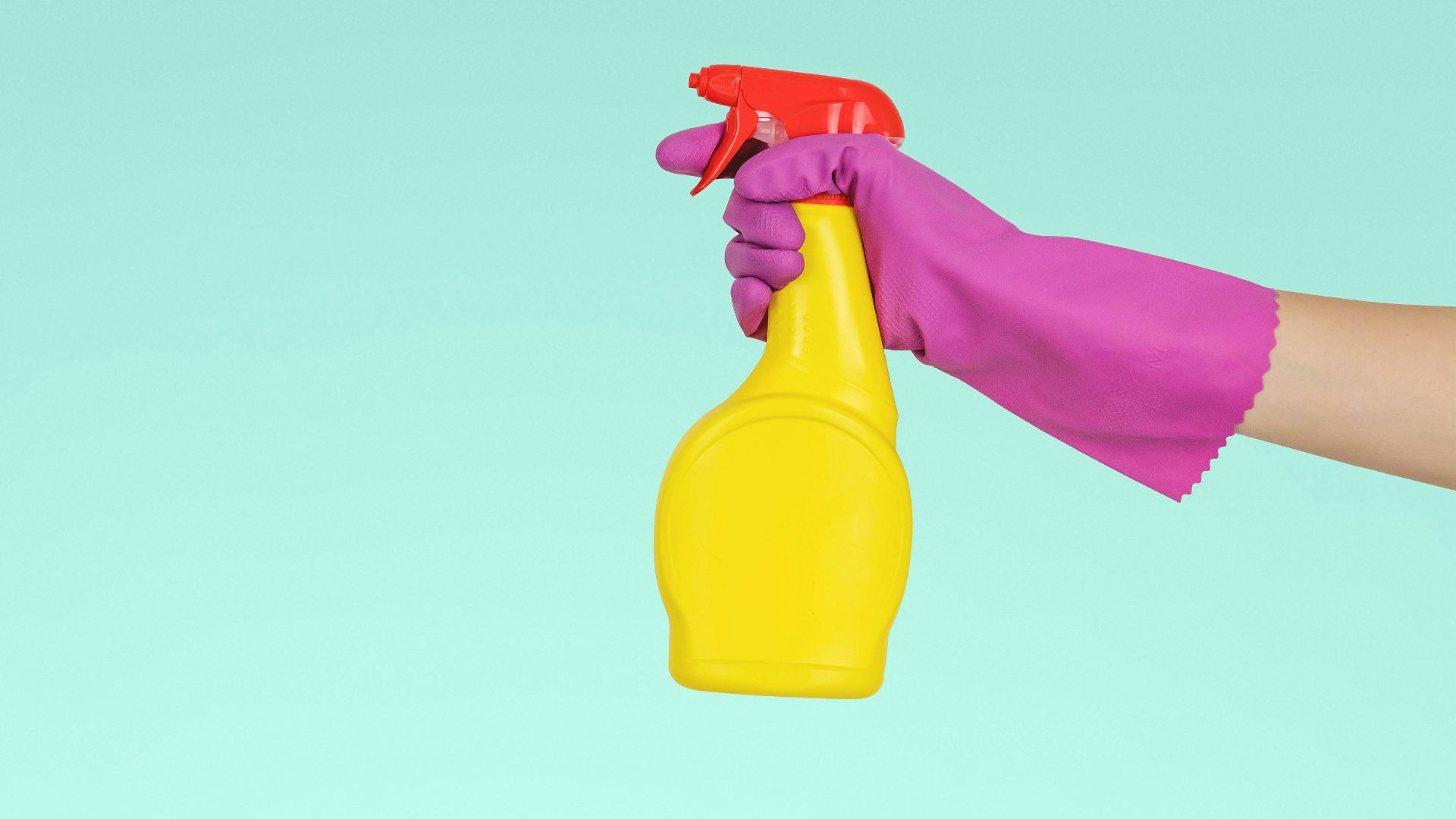 person holding yellow plastic spray bottle