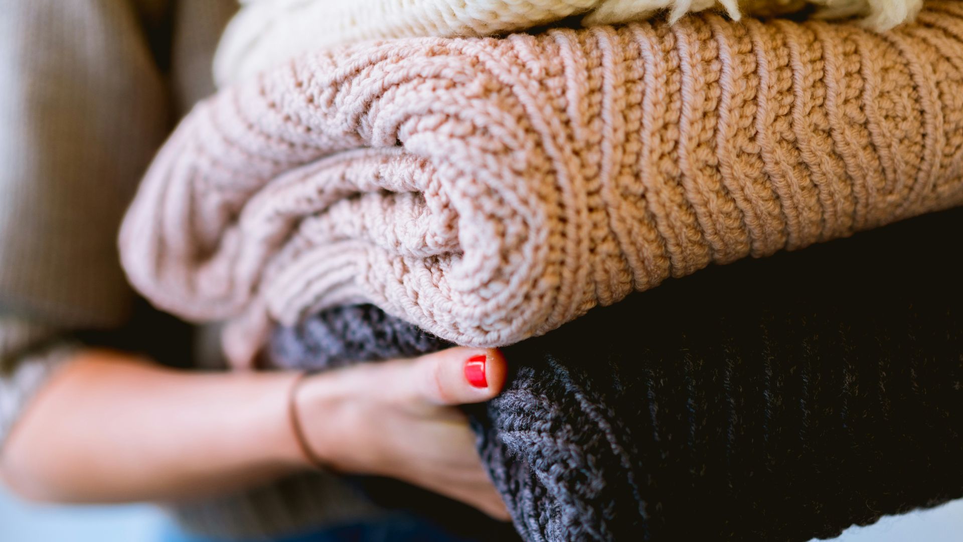 person holding knitted textiles
