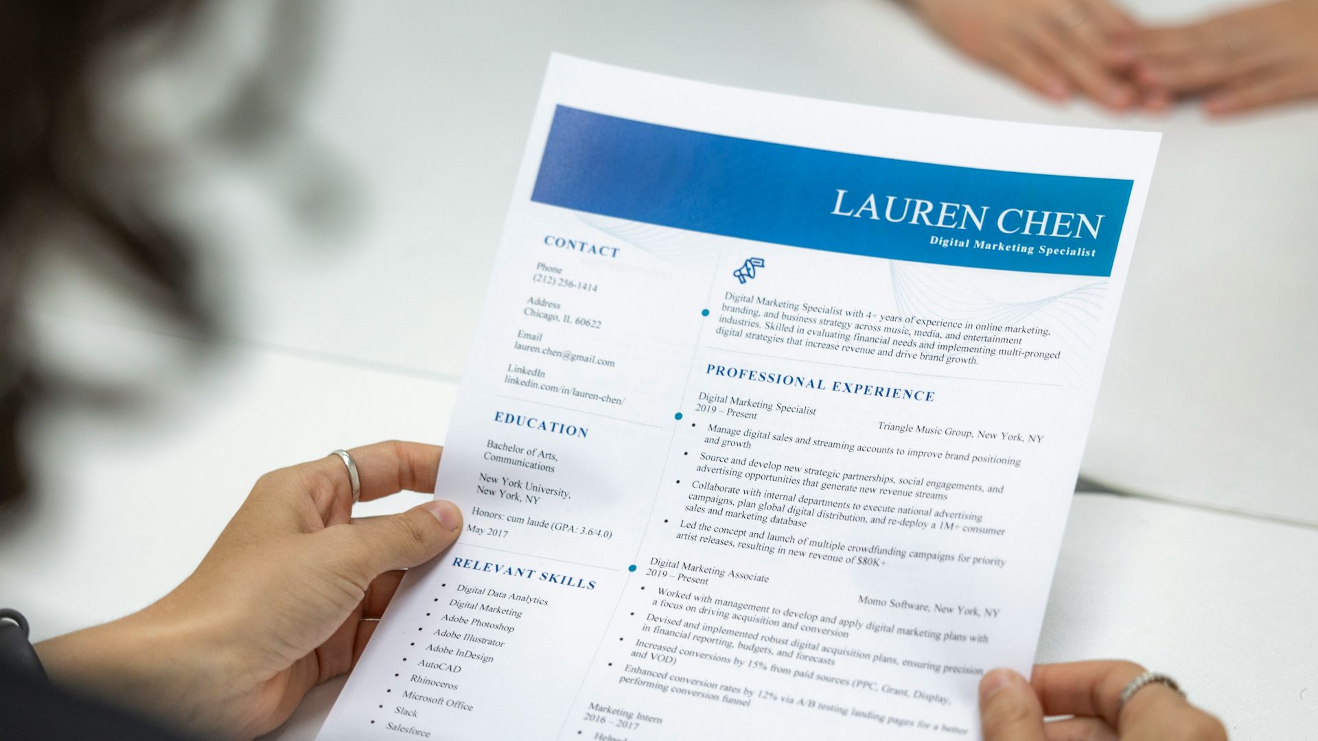 a woman is reading a resume at a table