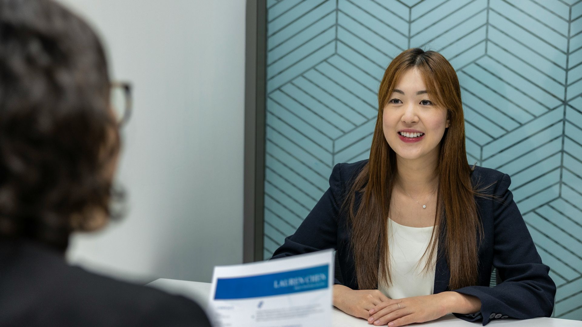 a woman sitting at a table with a piece of paper in front of her