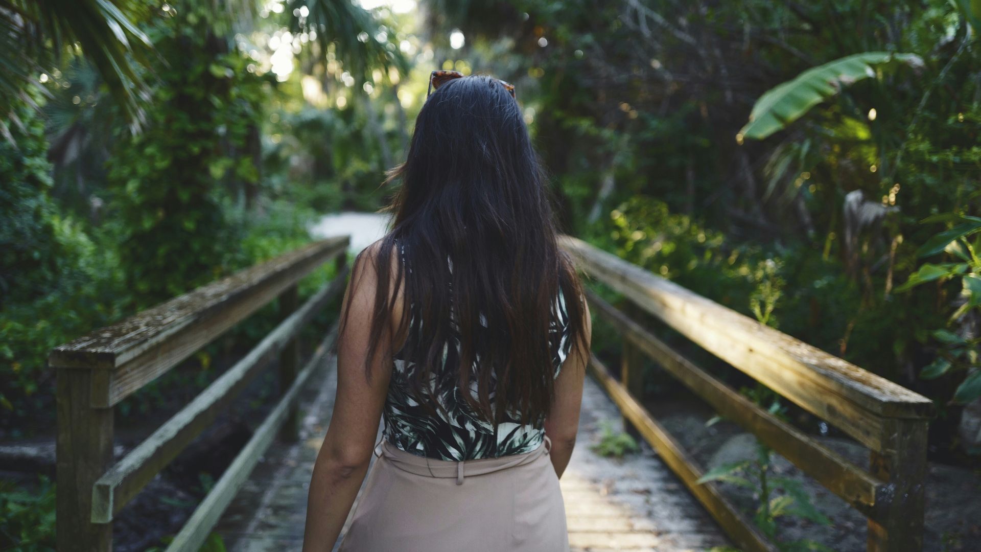 woman wearing black sleeveless top walking on dock