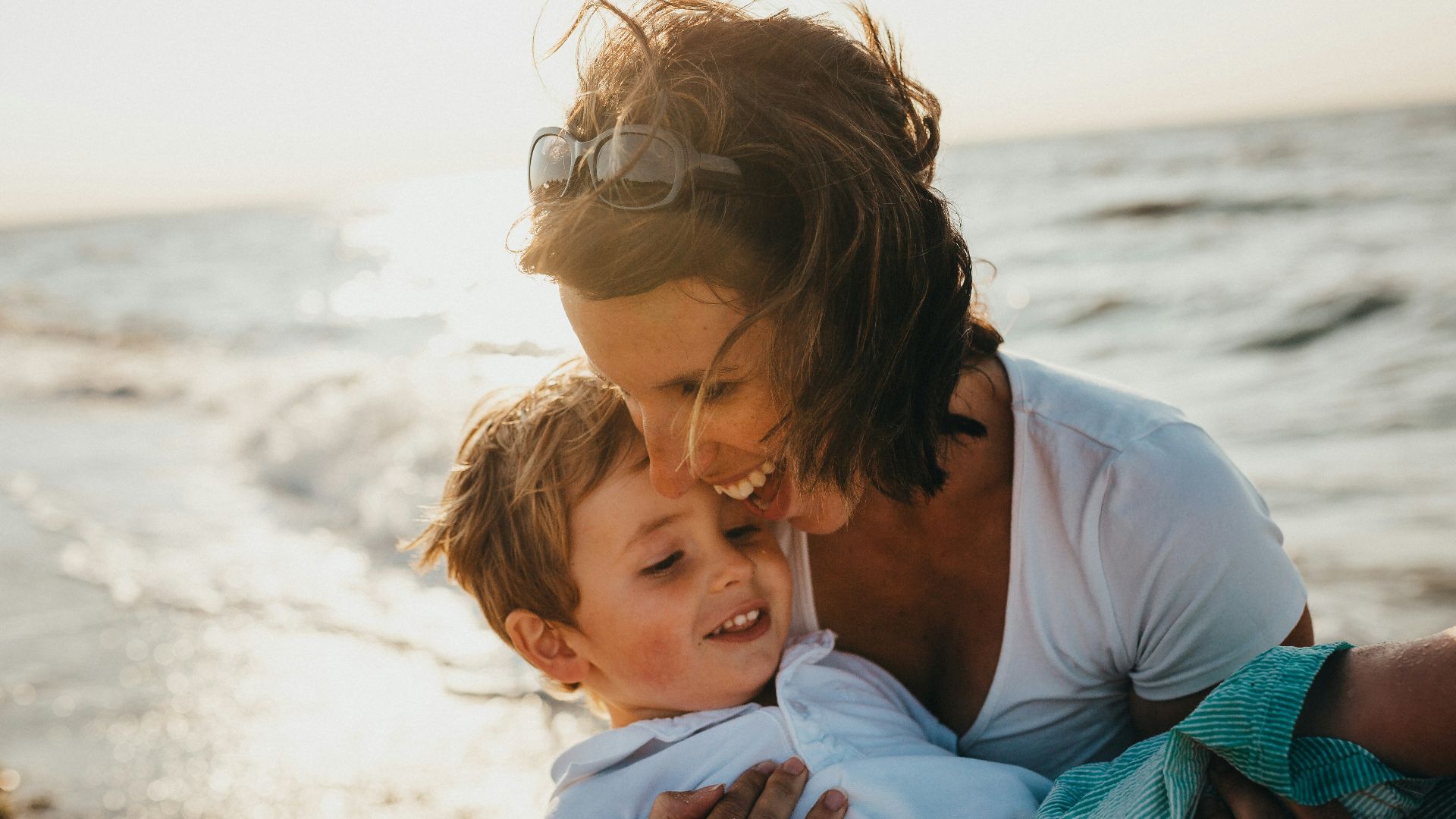 photo of mother and child beside body of water