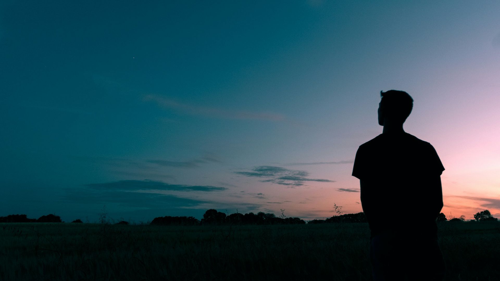 silhouette of man looking star during sunset