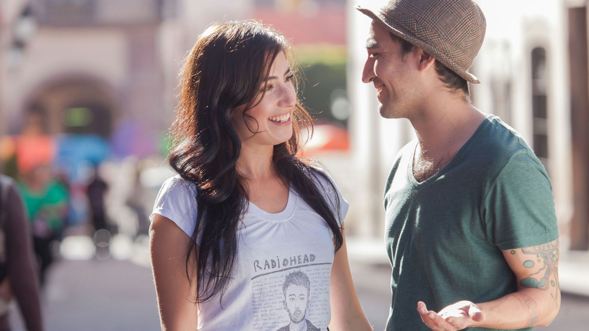 woman in gray crew neck t-shirt and gray fedora hat standing beside woman in gray