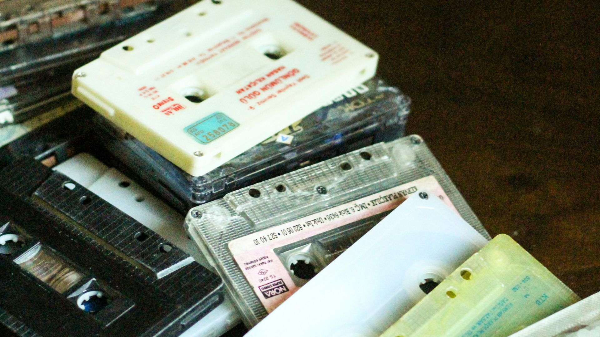 a pile of cassettes sitting on top of a wooden table