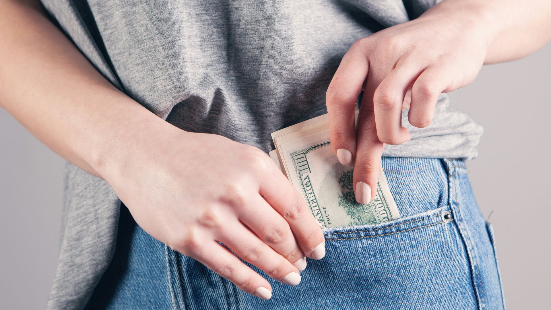 person in gray shirt and blue denim jeans holding blue denim jeans