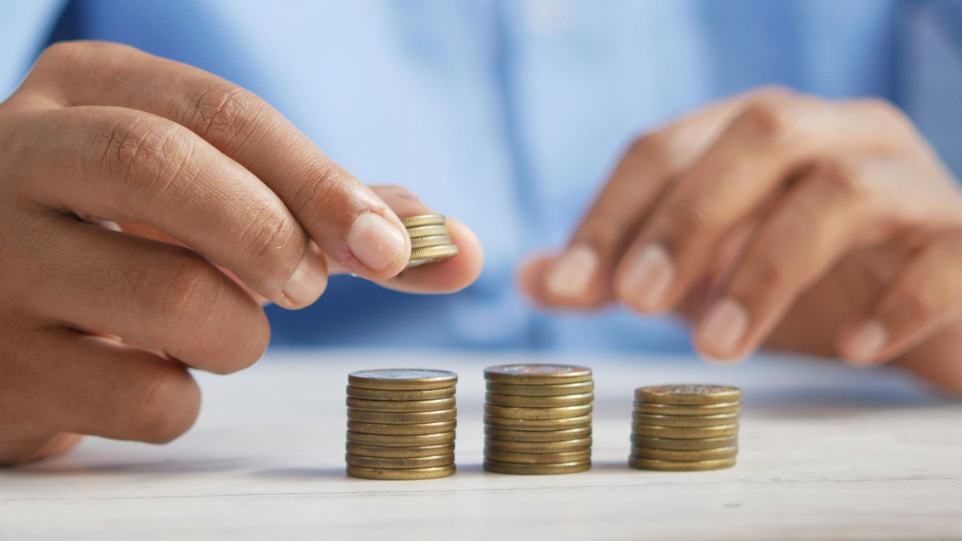 a person stacking coins on top of a table