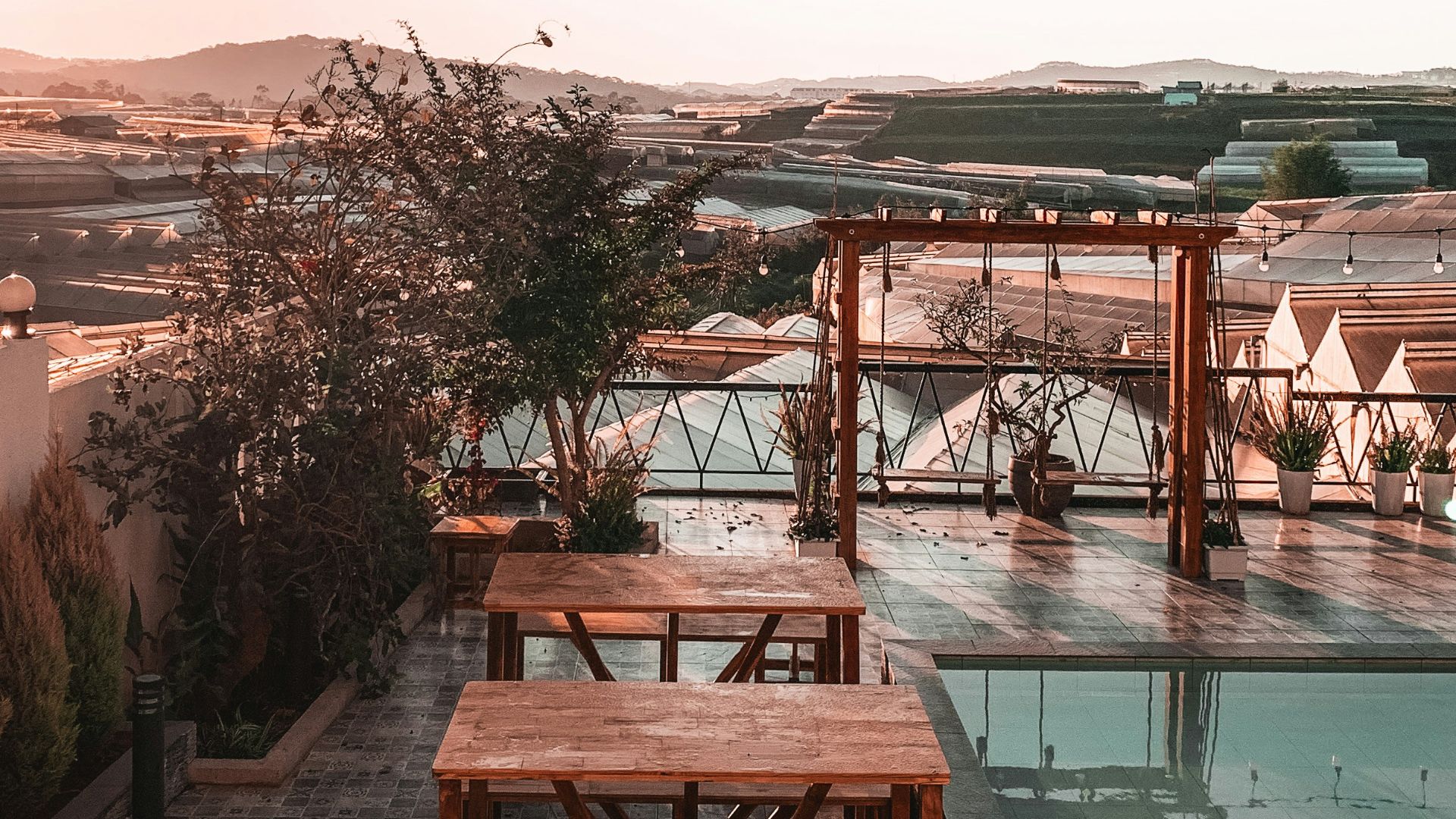 brown wooden table and chairs near swimming pool during daytime