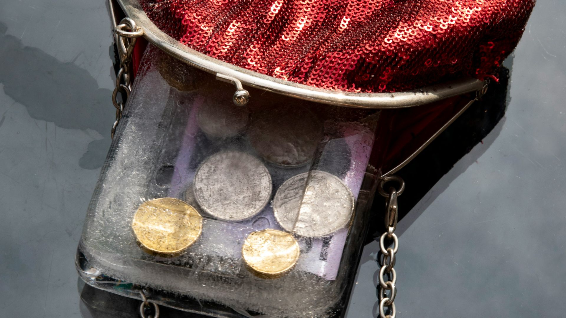 a purse with coins in it sitting on the water