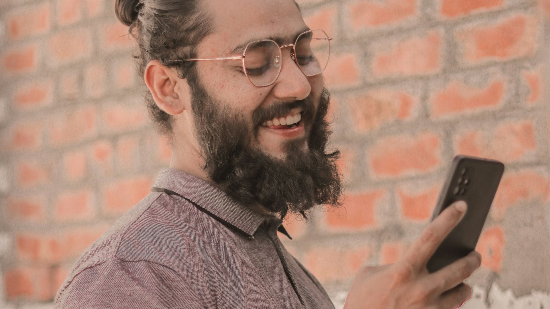 a man with a beard using a cell phone