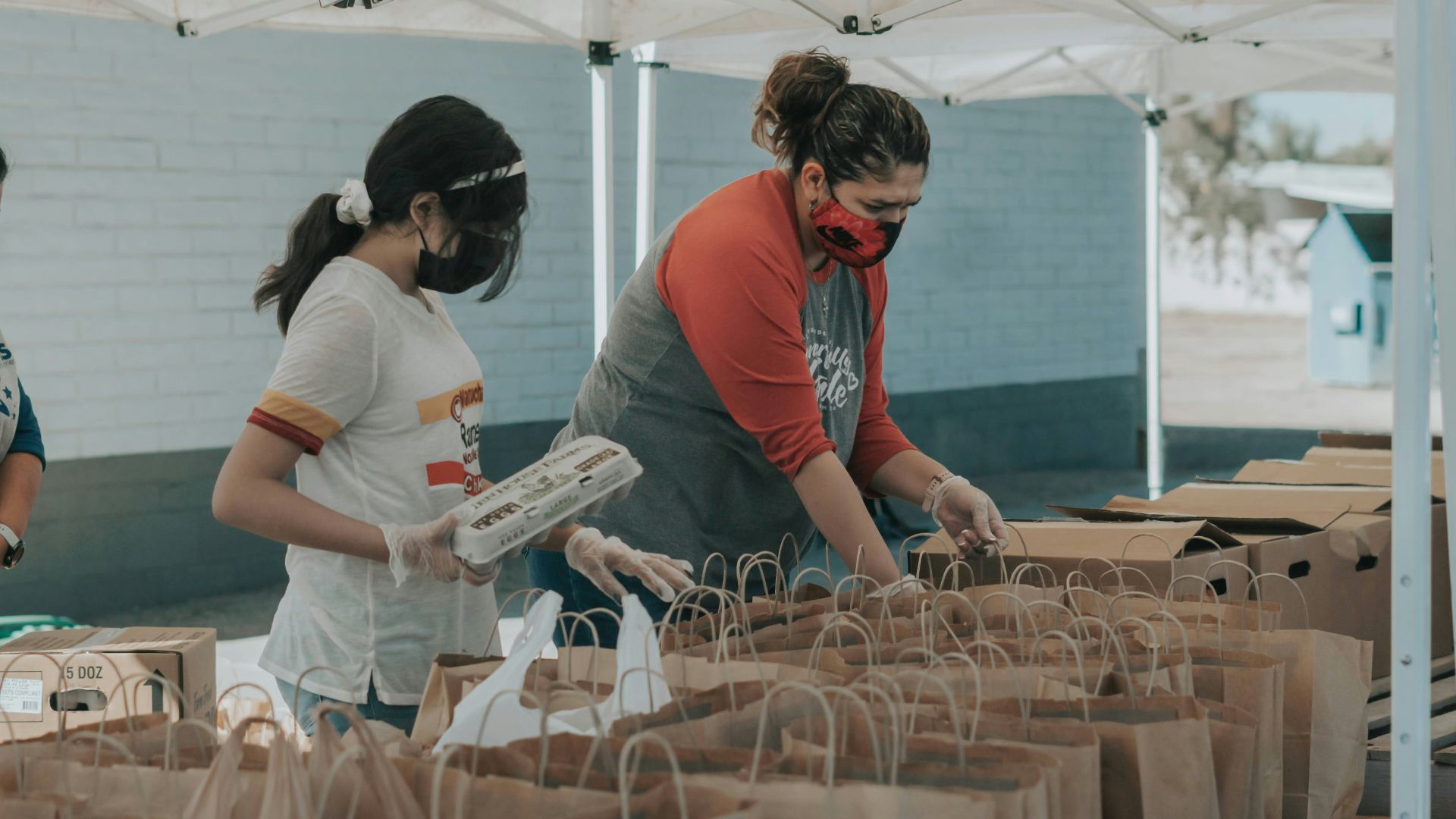 man in red t-shirt holding white plastic bottle