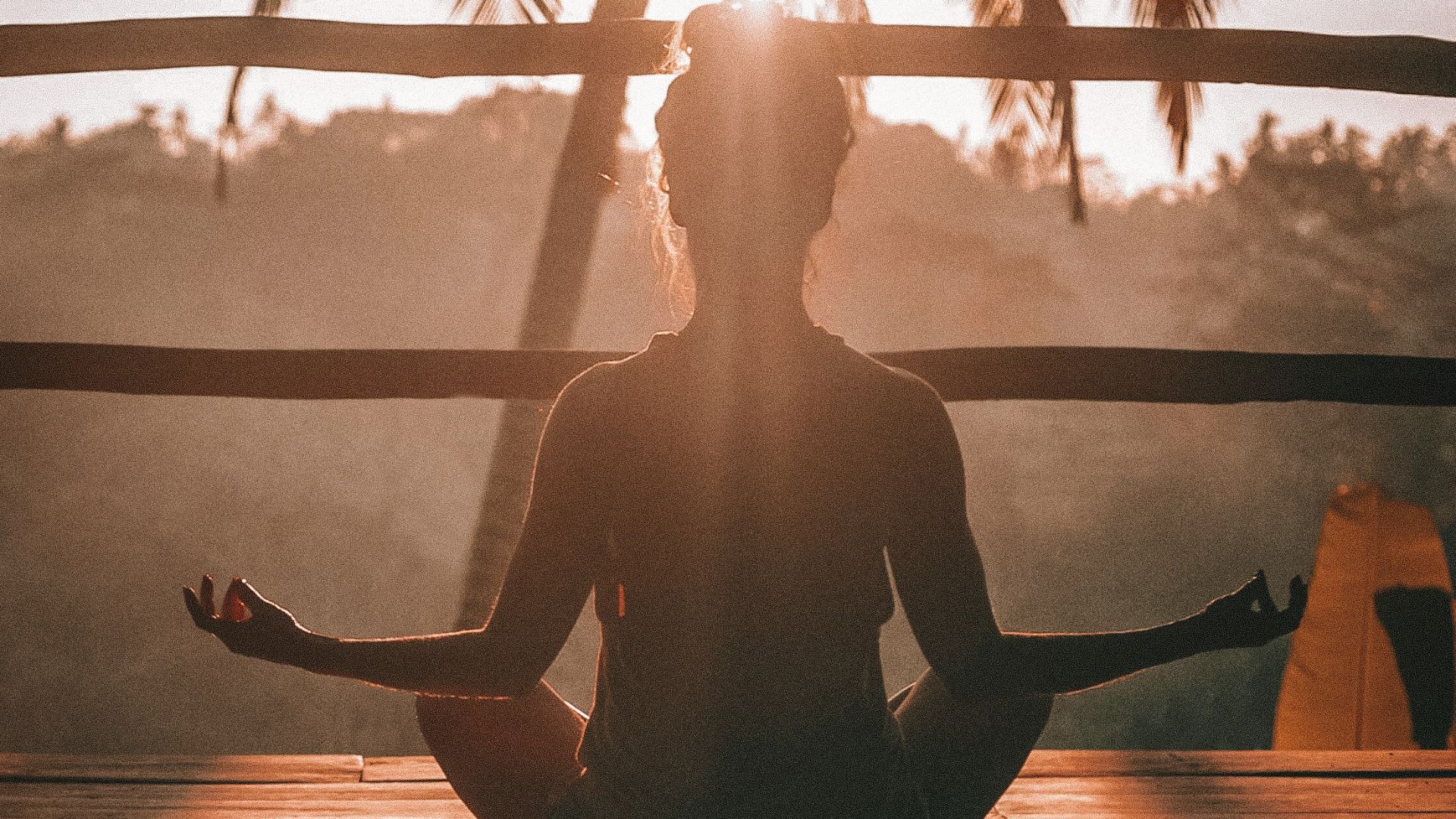 woman doing yoga meditation on brown parquet flooring