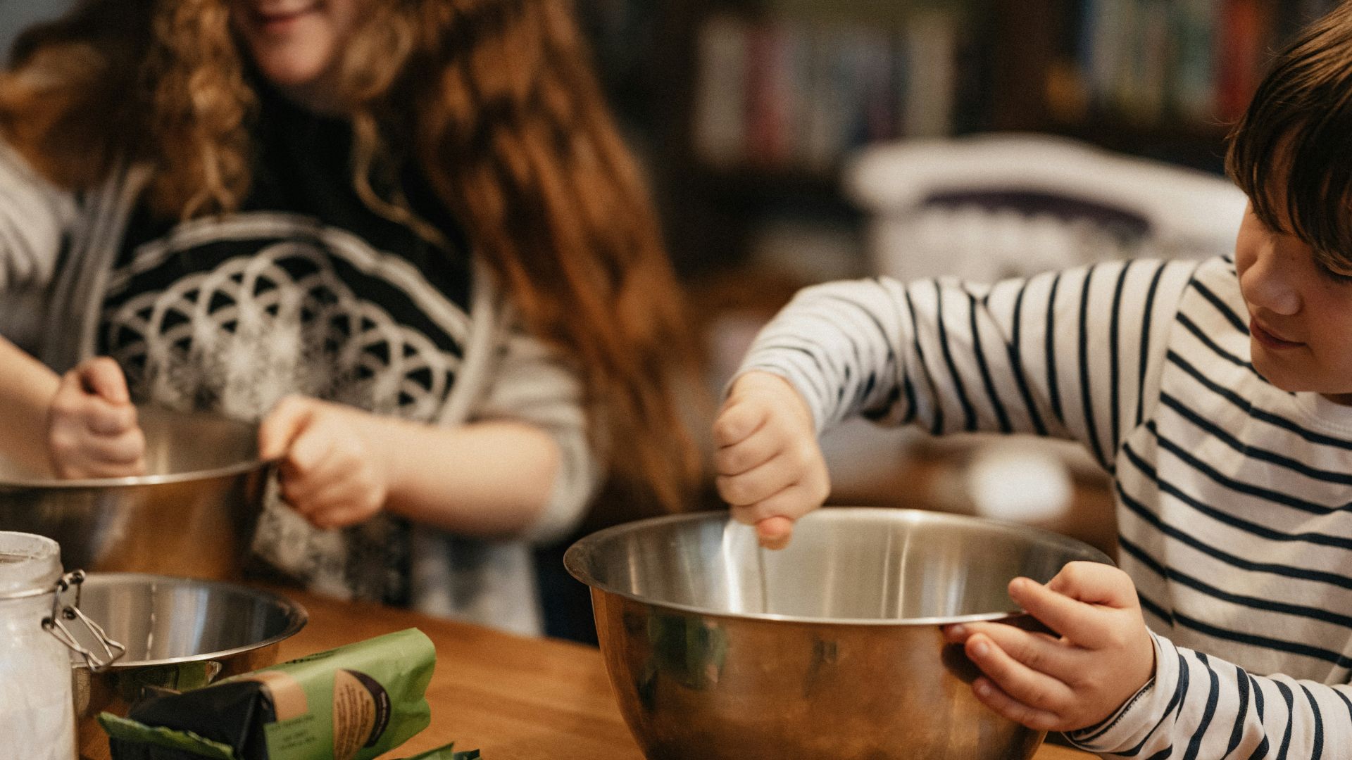 woman in black and white striped long sleeve shirt holding stainless steel bowl