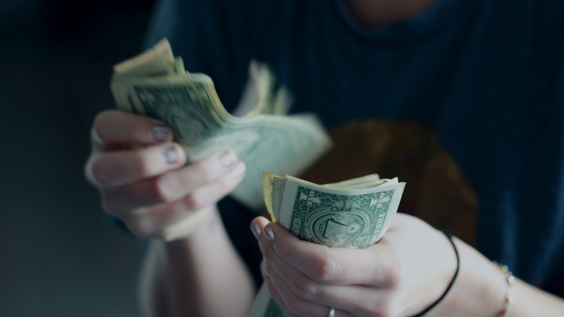 focus photography of person counting dollar banknotes