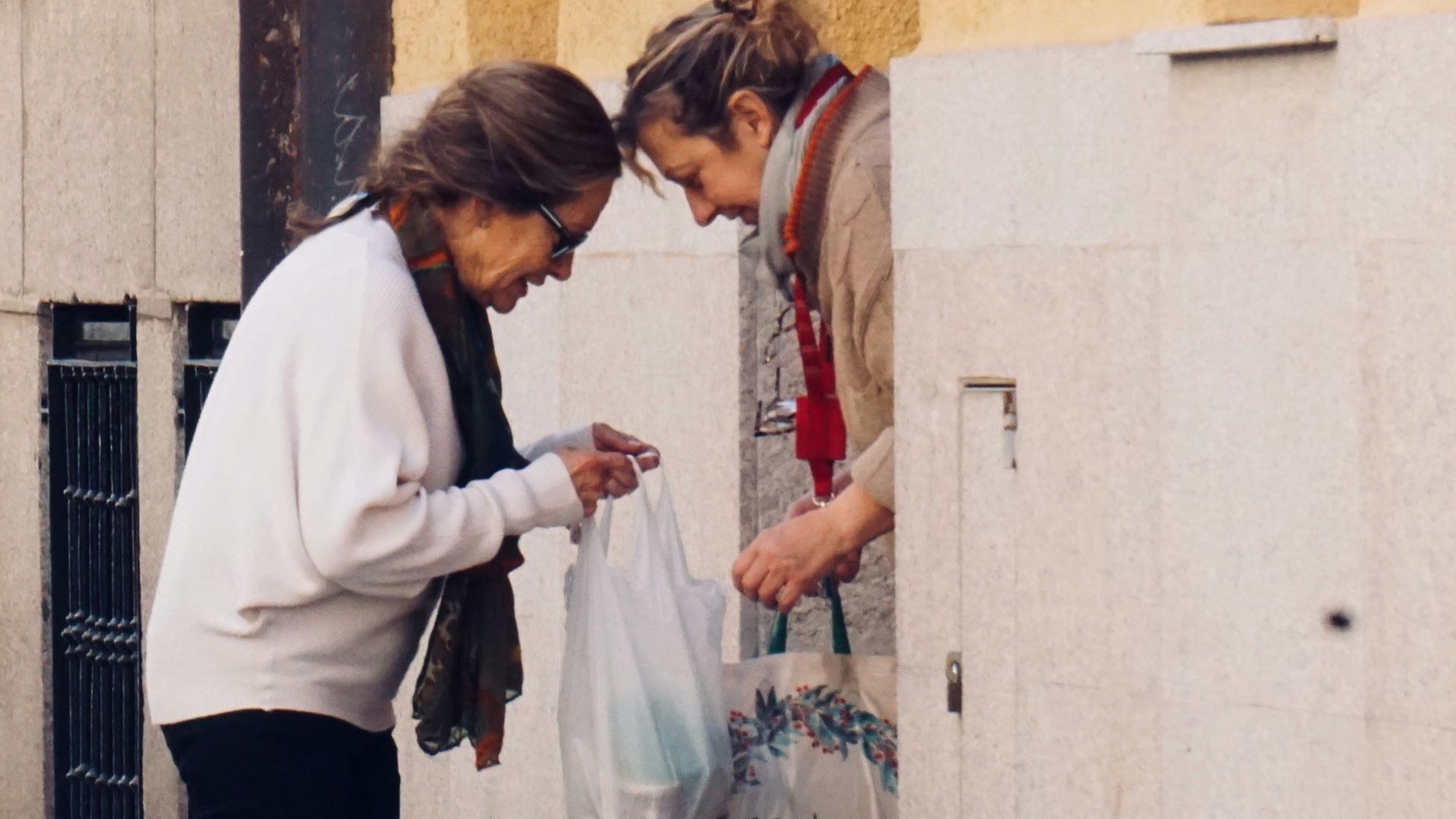 woman in white long sleeve shirt and black pants standing on sidewalk during daytime