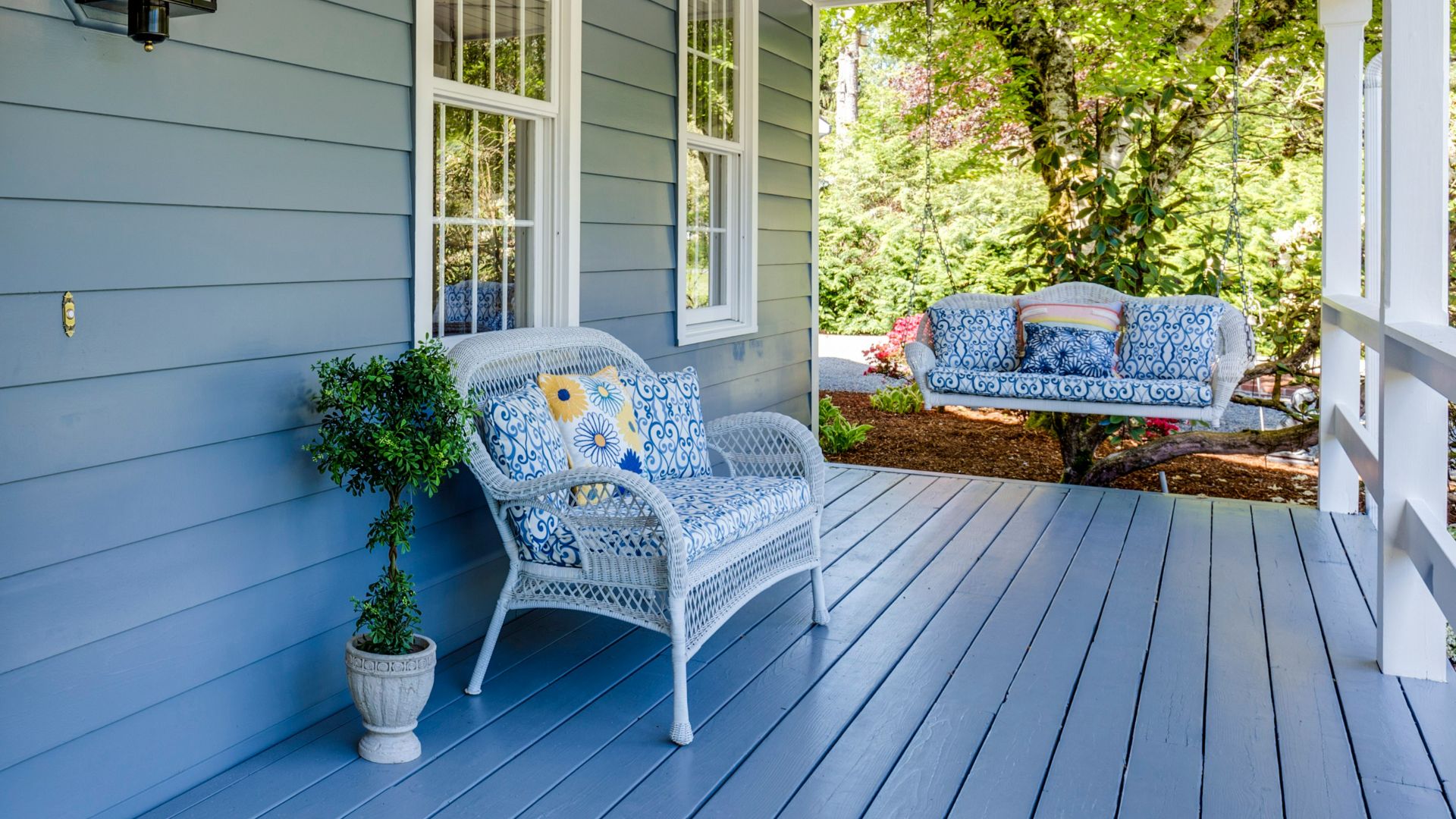 a porch with two chairs and a table on it