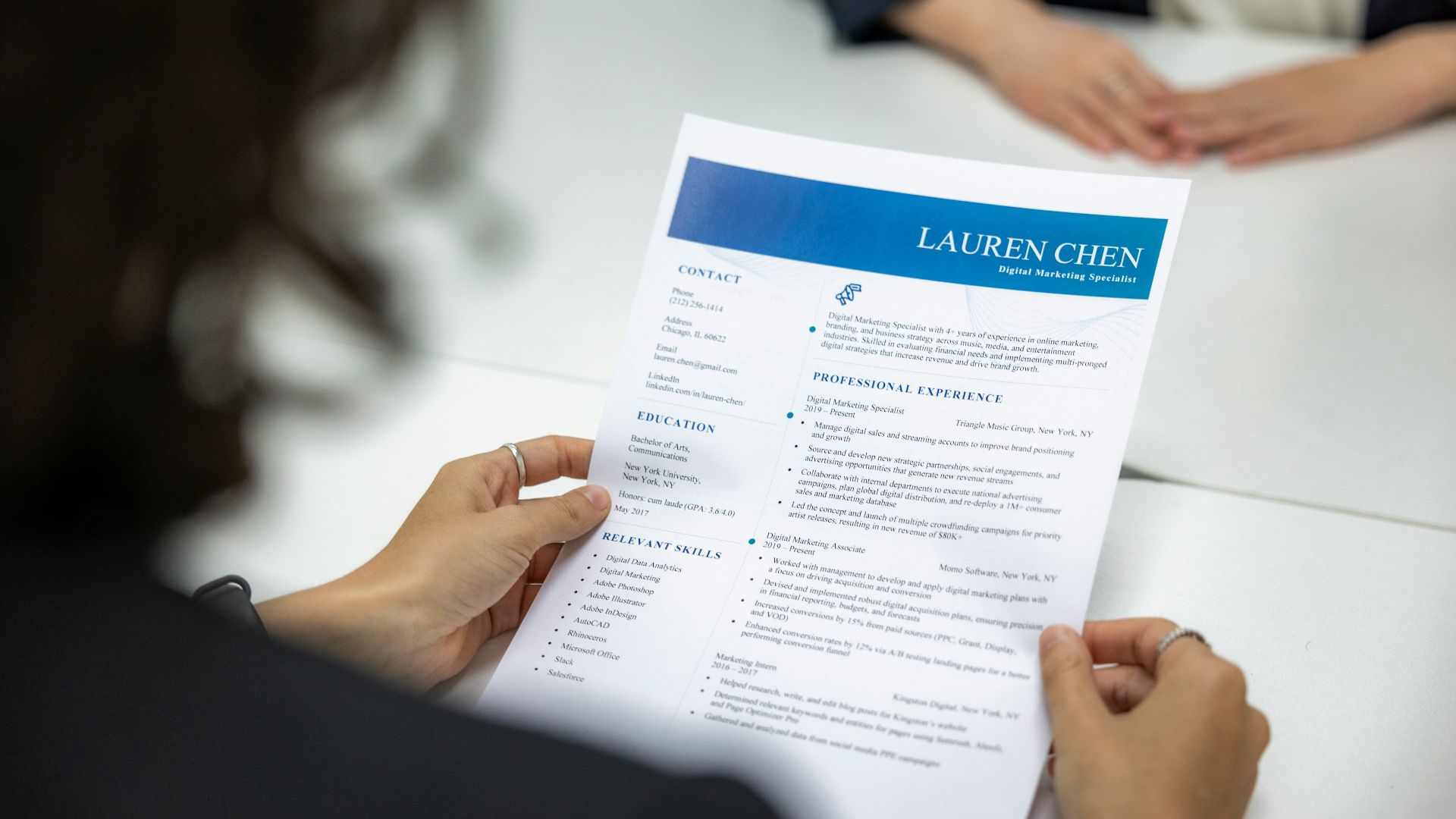 a woman is reading a resume at a table