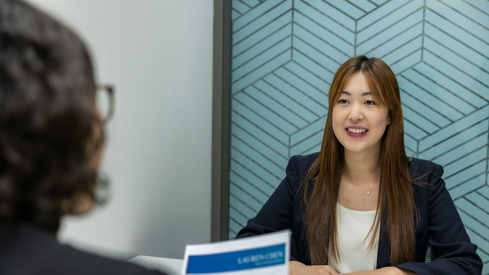 a woman sitting at a table with a piece of paper in front of her