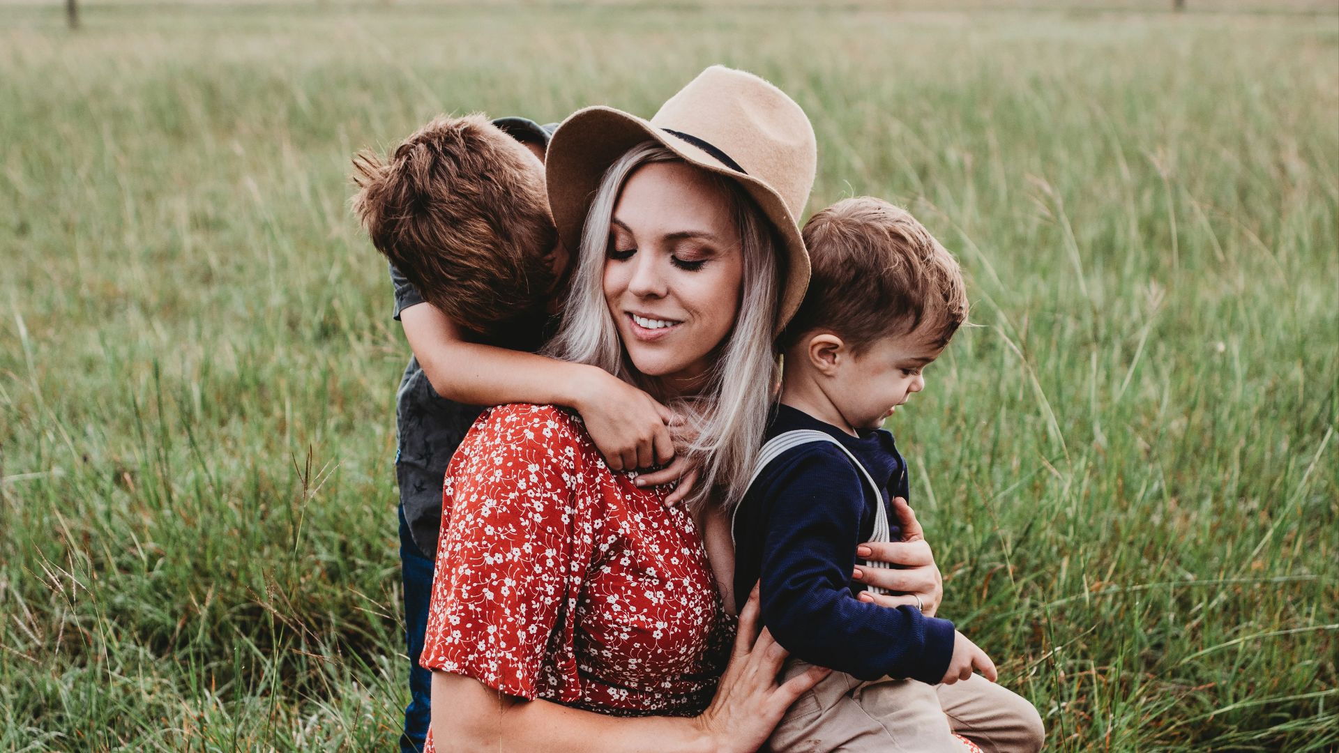 man and two children on grass field