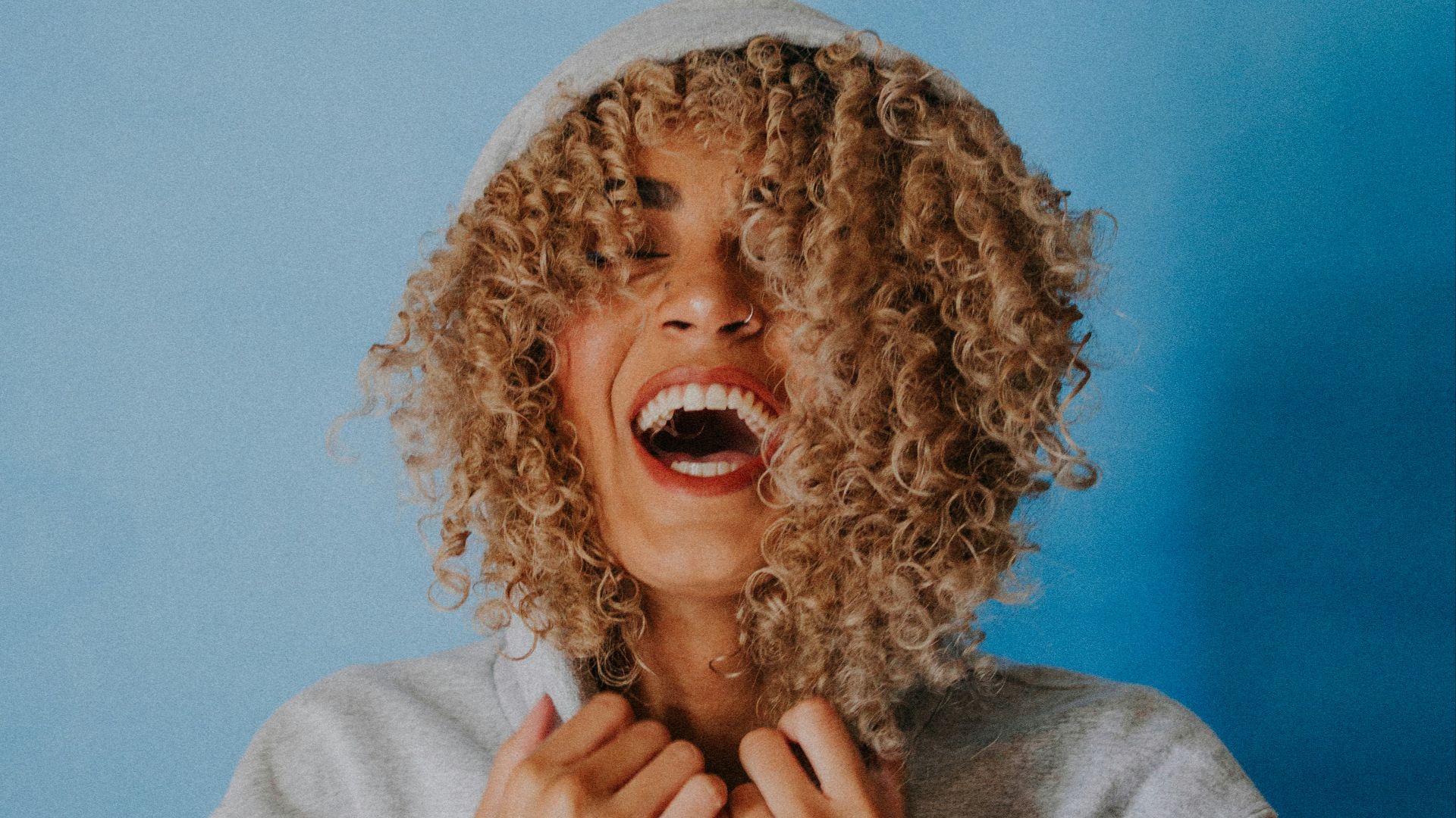 smiling woman wearing gray hoodie