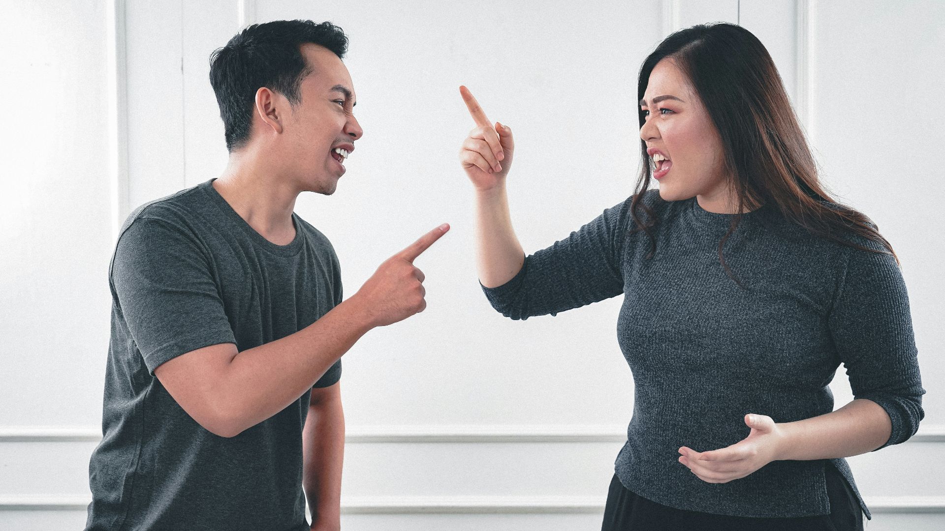 man in gray crew neck long sleeve shirt standing beside woman in black crew neck shirt