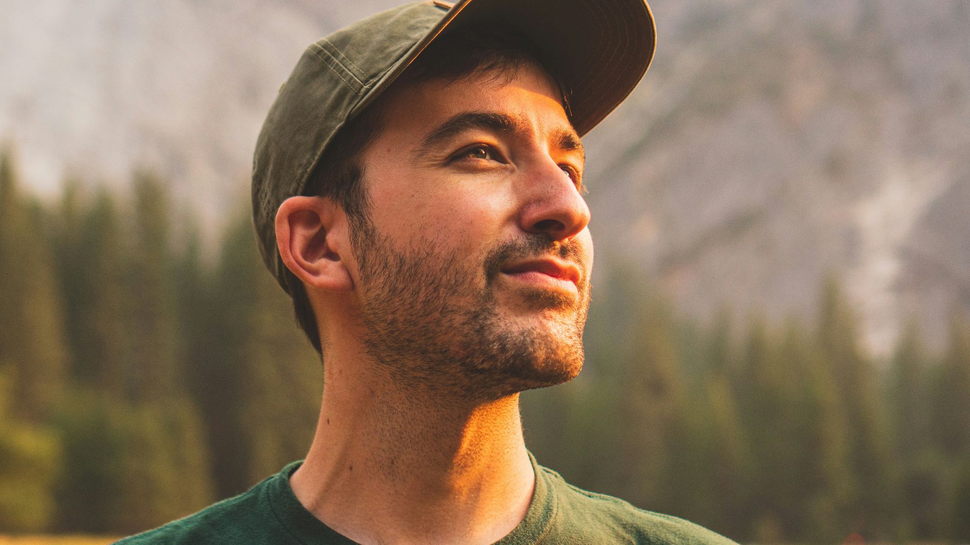 man in green crew neck shirt and black hat