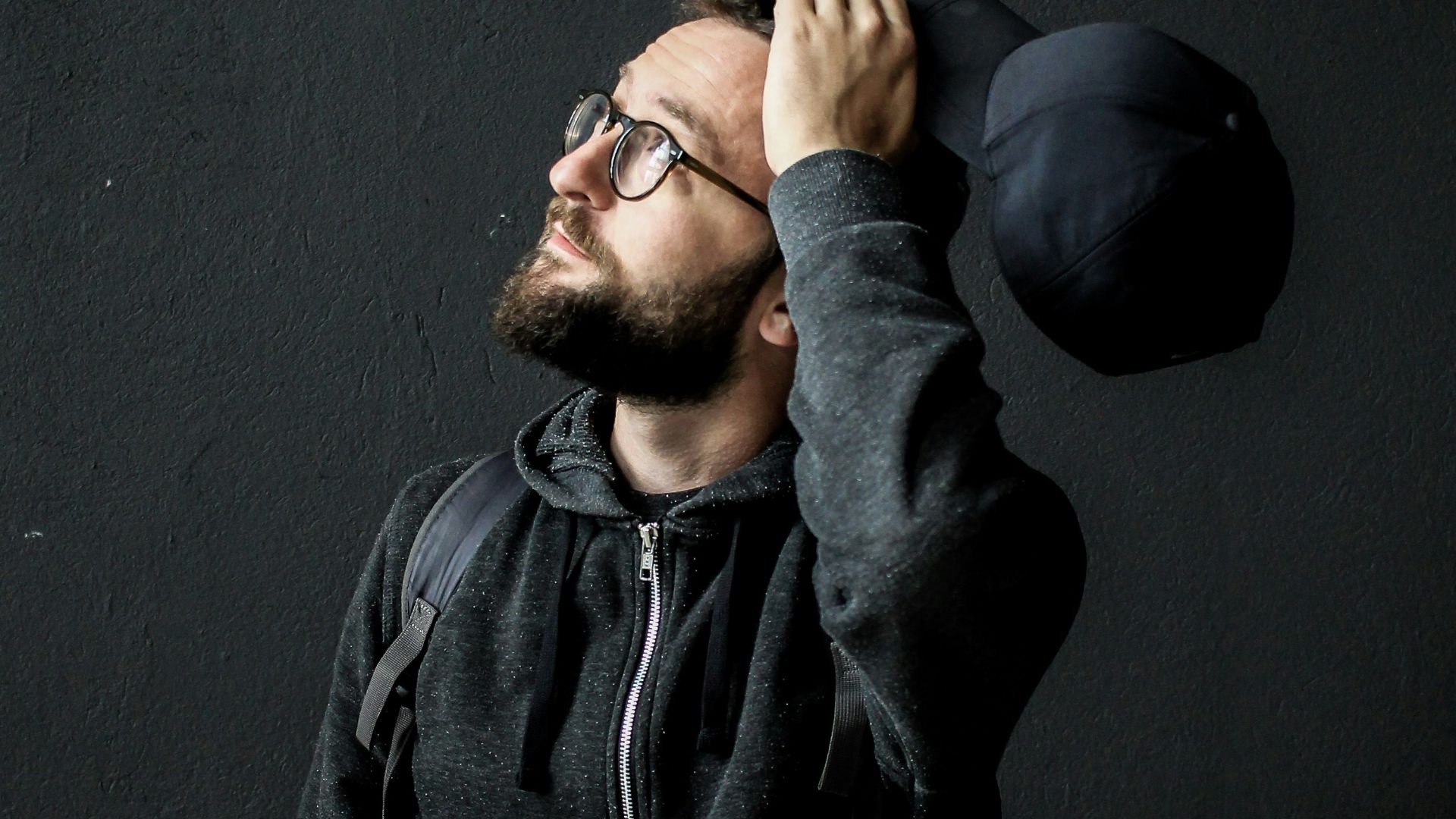 man looking up holding his hair