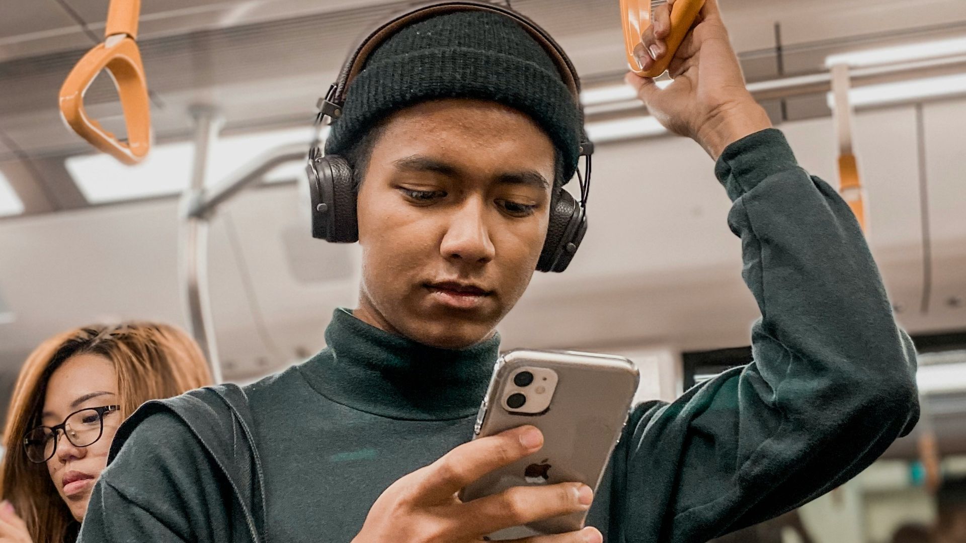 man in train holding smartphone