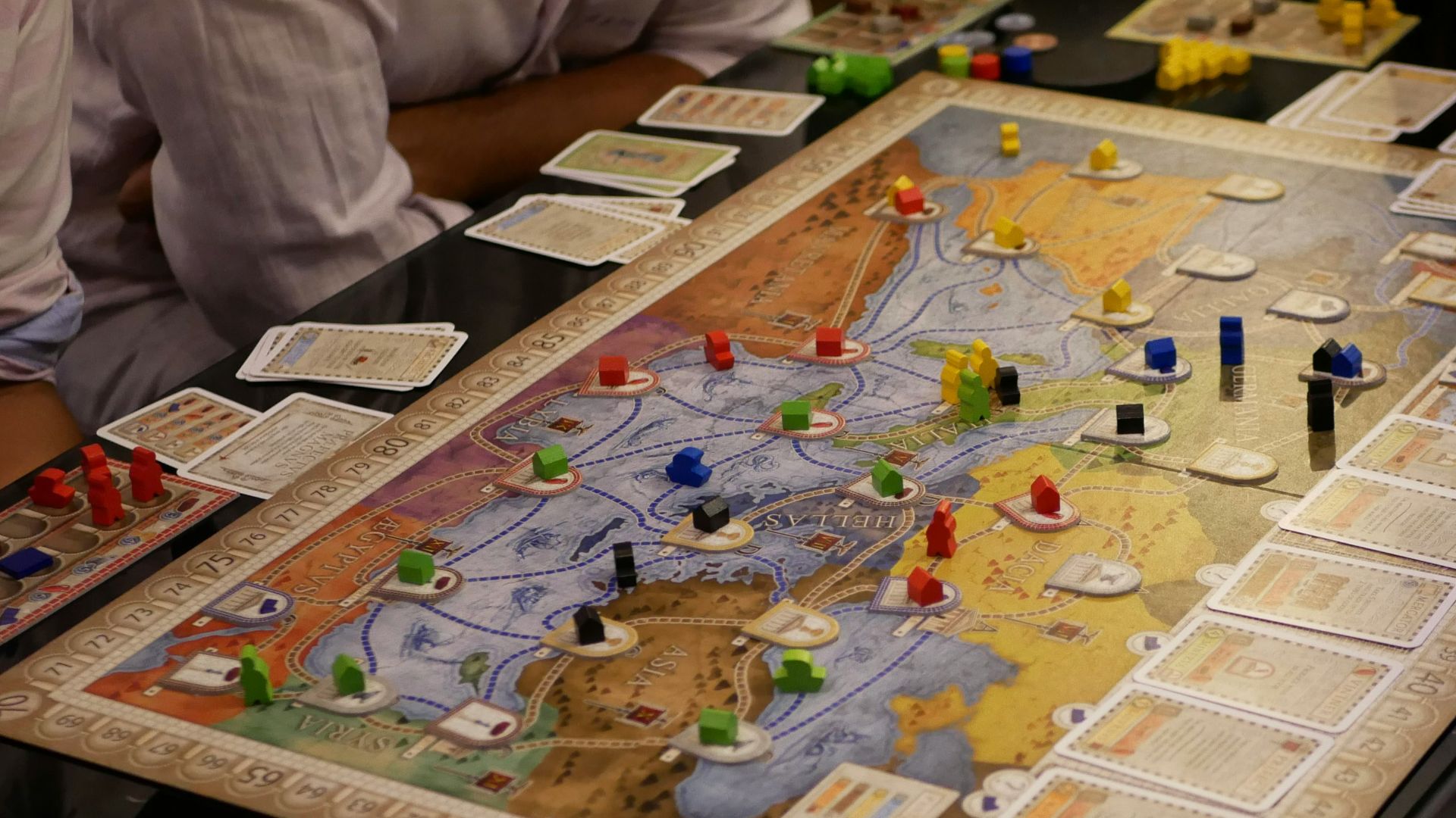 person in white shirt sitting beside table with puzzle game