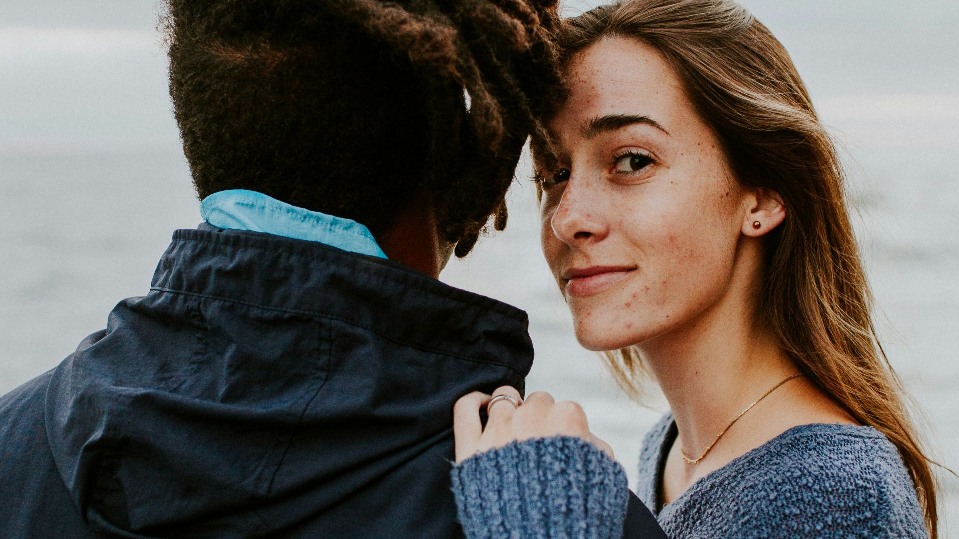 woman in blue long sleeve shirt beside woman in gray long sleeve shirt