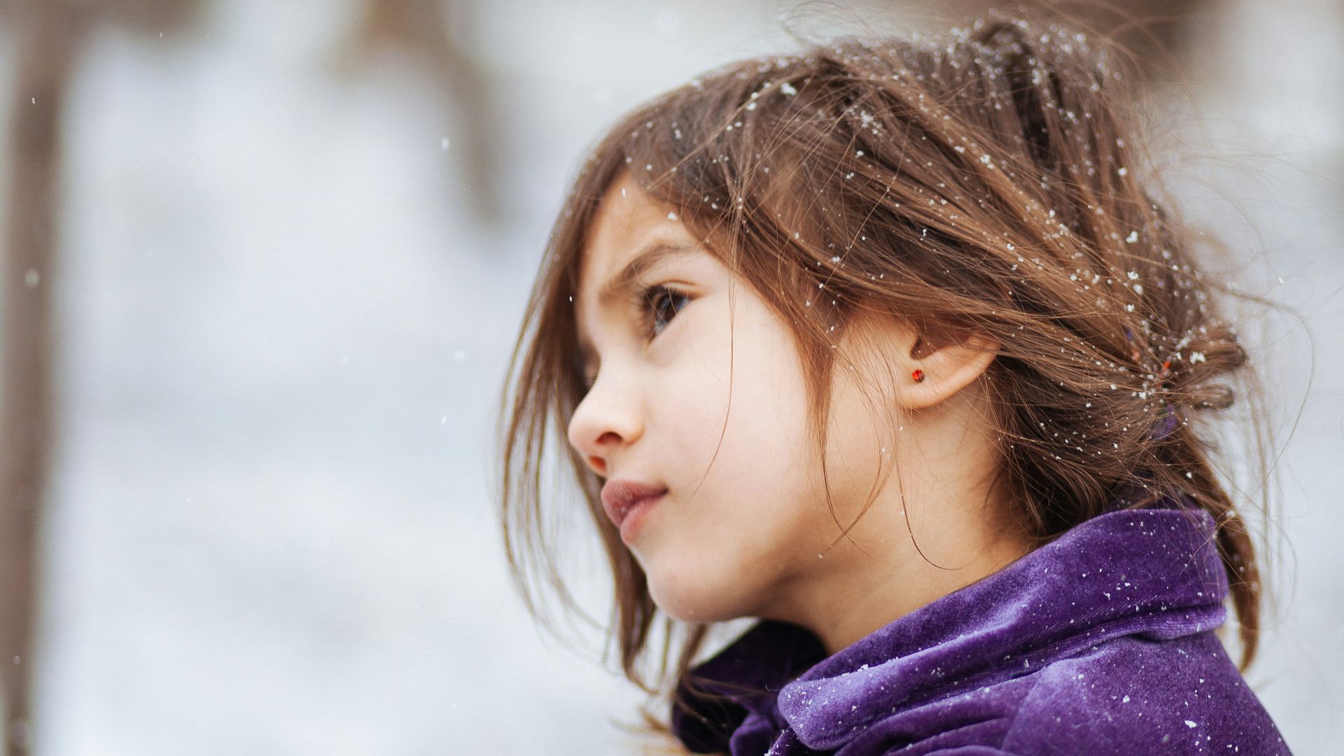 girl wearing purple jacket across blurry background