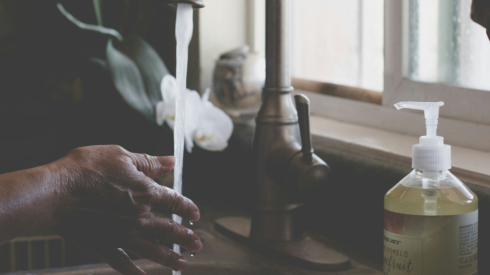person holding white plastic pump bottle