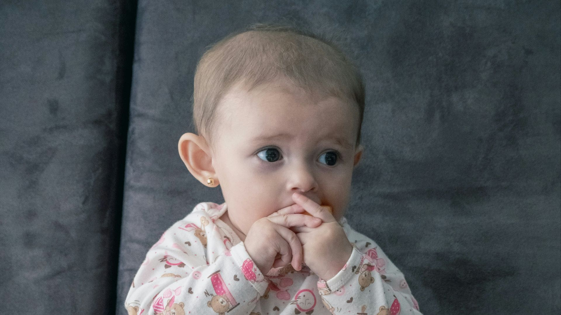 baby in white and pink onesie sitting on green and white ceramic plate