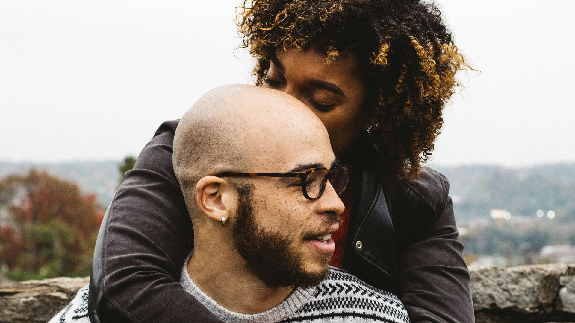 woman kissing man's head