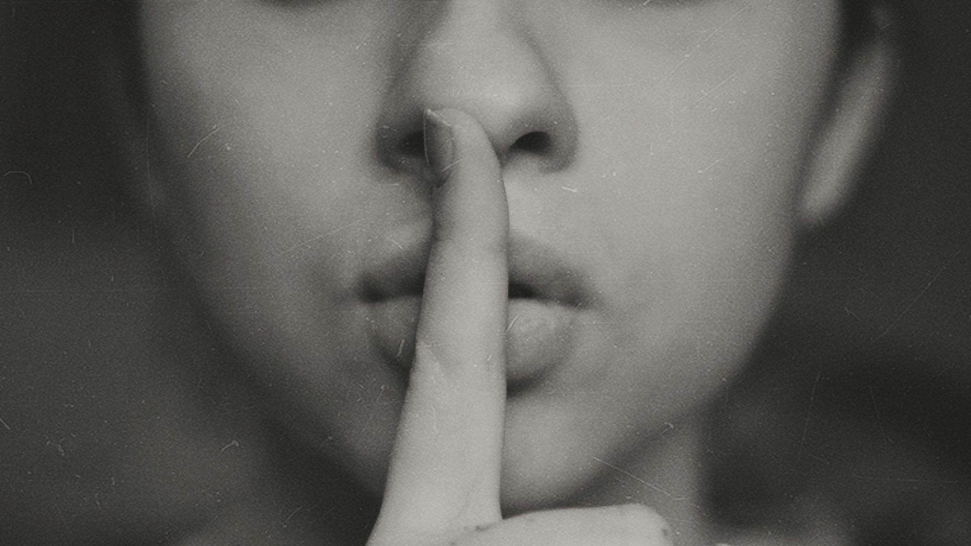 grayscale photo of woman doing silent hand sign